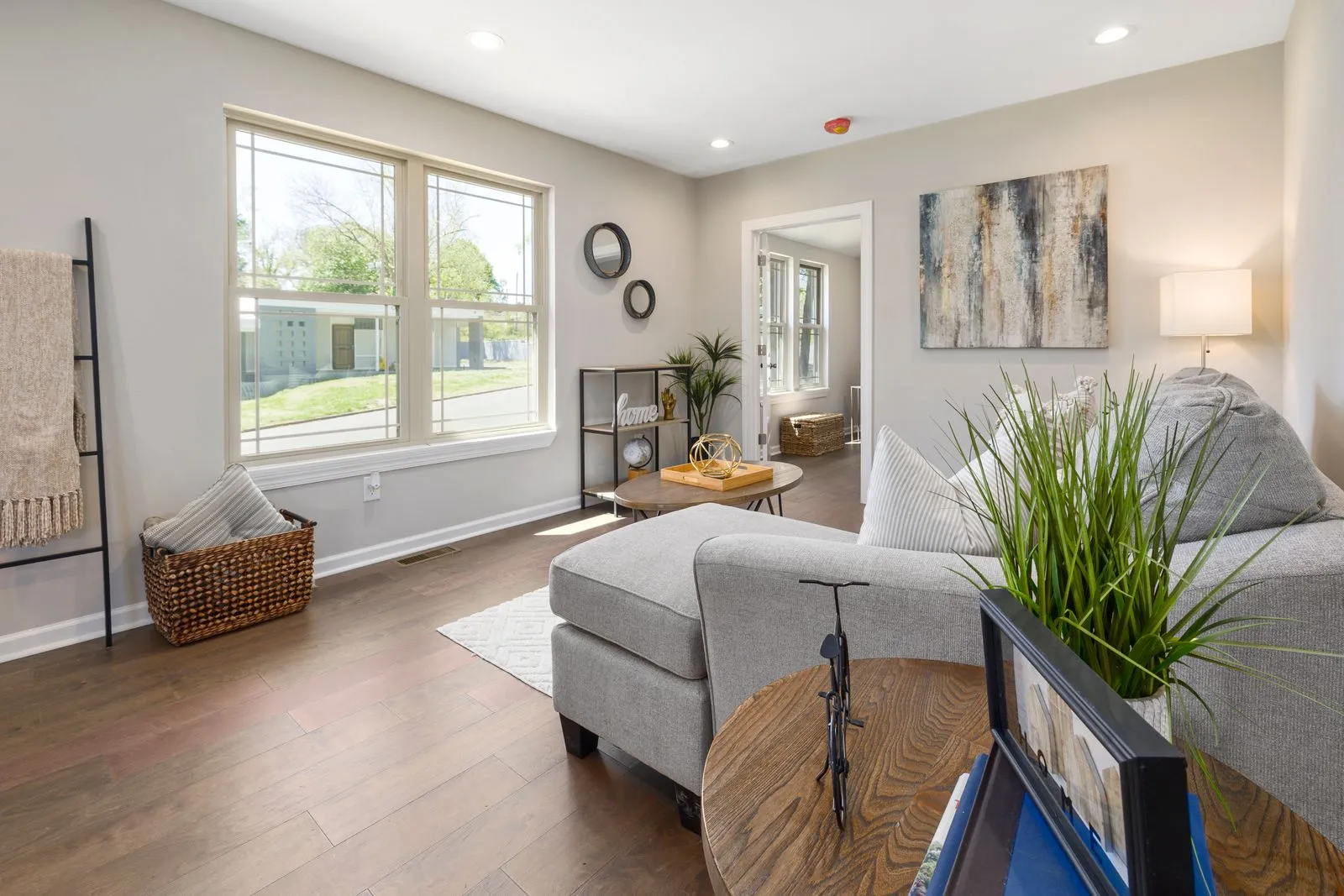 Bright and spacious modern living room with elegant decor and wooden flooring.